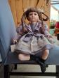 Poup�e de collection en porcelaine � tresses assise mauve 33 cm